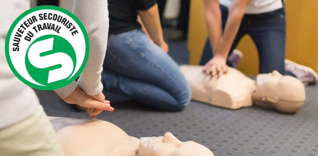 Exercice pratique de massage cardiaque (RCP) sur mannequin lors d'une session Sauveteur Secouriste du Travail avec le logo officiel SST.